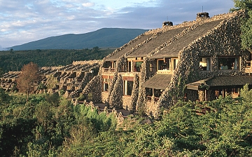 The rock facade of the lodge blends into the environment on the crater rim.